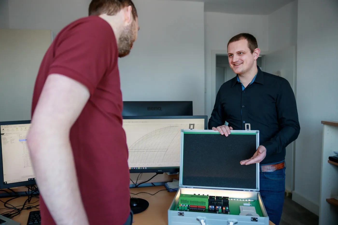 Energieingenieure im Büro — Mitarbeiter präsentiert Messkoffer